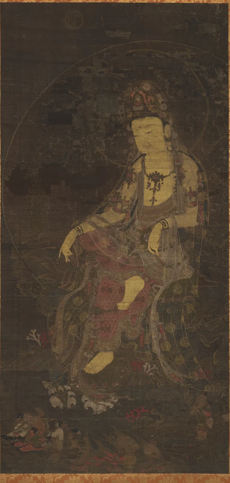 고려의 수월관음도. 어두운 갈색으로 바랜 세로로 긴 비단 화면에 관음보살이 바위에 비스듬히 기대앉아 있다. 머리에 화려한 관을 쓰고, 오른발을 왼쪽 무릎 위에 올렸다. 몸은 붉은 옷과 흐릿한 무늬 옷으로 덮여 있고, 금빛 선이 옷 가장자리를 따라 희미하게 남아 있다. 둥근 광배가 몸 뒤를 감싼다. 아래 왼쪽 구석에 작은 형상이 보인다.